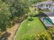 Fenced backyard with lush green lawn, a charming bird feeder feature, and a screened-in pool area at 2676 Estuary Loop, Oviedo, FL 32765