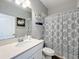 Bright bathroom features a quartz countertop, stylish mirror, and modern shower with decorative curtain at 2676 Estuary Loop, Oviedo, FL 32765