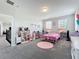 Bright bedroom features two windows, gray carpet, and pink accents at 2676 Estuary Loop, Oviedo, FL 32765