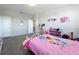 Comfortable bedroom with gray carpet and bright pink comforter at 2676 Estuary Loop, Oviedo, FL 32765