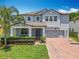 Charming two-story home featuring a well-manicured lawn and a brick driveway leading to a two-car garage at 2676 Estuary Loop, Oviedo, FL 32765