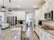 Modern kitchen with granite countertops, stainless steel appliances, and wood-look tile flooring at 2676 Estuary Loop, Oviedo, FL 32765