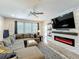 Open-concept living room featuring a large sectional sofa and modern fireplace with stone-look surround at 2676 Estuary Loop, Oviedo, FL 32765