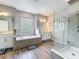Bright bathroom features a double vanity, glass shower and large tub at 2676 Estuary Loop, Oviedo, FL 32765
