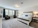 Serene main bedroom with a king bed, side tables, and windows allowing natural light to create a calm space at 2676 Estuary Loop, Oviedo, FL 32765
