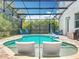 Inviting screened in pool features built-in sun loungers, a basketball hoop and mature landscaping at 2676 Estuary Loop, Oviedo, FL 32765