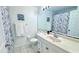 Clean bathroom with tiled floors, neutral countertops, and a shower with a patterned shower curtain at 3129 Arrow Dr, Kissimmee, FL 34746
