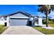 Charming single-Gathering home featuring a gray two-car garage and a well-manicured lawn at 3129 Arrow Dr, Kissimmee, FL 34746