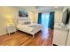 Bright main bedroom featuring hardwood floors, a king bed, and sliding glass doors to the outside at 3129 Arrow Dr, Kissimmee, FL 34746