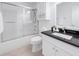 Clean, modern bathroom with a shower-tub, and vanity with dark countertops and ample storage at 3260 Pinto Dr, Kissimmee, FL 34746