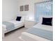 Inviting bedroom with two twin beds, white furniture, a nightstand, and a window with light-filtering blinds at 3260 Pinto Dr, Kissimmee, FL 34746