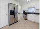 Bright kitchen with white cabinets, stainless steel appliances including a refrigerator, and dark countertops at 3260 Pinto Dr, Kissimmee, FL 34746