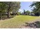Expansive backyard with mature trees, lush green grass, and a charming storage shed at 360 W University Ave, Orange City, FL 32763