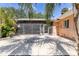 Beautiful patio area surrounded by lush palm trees, complemented by the home's light peach exterior at 360 W University Ave, Orange City, FL 32763