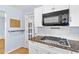 Modern kitchen features a gas range, white cabinets, granite counters and a stainless microwave oven at 360 W University Ave, Orange City, FL 32763