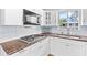 Bright kitchen showcases stainless steel appliances, light countertops, white cabinets, and a double sink at 360 W University Ave, Orange City, FL 32763