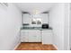Compact kitchenette with white cabinets, stainless steel sink, and a view to the outdoors at 360 W University Ave, Orange City, FL 32763