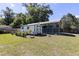 Charming backyard shed with a covered carport, set against a backdrop of lush greenery at 360 W University Ave, Orange City, FL 32763