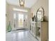 Bright entryway featuring white tiled floors, elegant console table, and decorative mirror at 4002 Richmond Xing, Leesburg, FL 34748