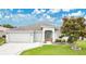 Inviting home with a three-car garage, a decorative walkway, and a lovely landscaped yard at 4002 Richmond Xing, Leesburg, FL 34748