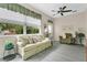Comfortable living room with a ceiling fan, floral couch, and large windows at 4002 Richmond Xing, Leesburg, FL 34748