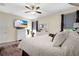Bright main bedroom with a ceiling fan, a television, and a white dresser at 4002 Richmond Xing, Leesburg, FL 34748