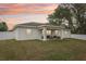 Enjoy this home's new backyard and back porch under a colorful sunset sky with a white fence at 5 Pecan Drive Crse, Ocala, FL 34472