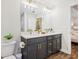 A dual sink vanity in a modern bathroom with gold hardware and light fixtures near the bedroom entrance at 5 Pecan Drive Crse, Ocala, FL 34472