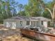 Exterior view with a white exterior, attached garage, and a spacious lot amidst a natural backdrop at 5 Pecan Drive Crse, Ocala, FL 34472