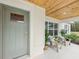 Inviting front porch with wood ceiling, features seating area and a painted front door at 5 Pecan Drive Crse, Ocala, FL 34472