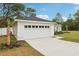 Side view of the 2-car garage, featuring carriage door and spacious driveway at 5 Pecan Drive Crse, Ocala, FL 34472