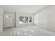 Bright living room with a large window overlooking the front porch and a door to a bedroom at 5 Pecan Drive Crse, Ocala, FL 34472