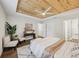 Bright main bedroom featuring a decorative wood ceiling, fan, and sitting area at 5 Pecan Drive Crse, Ocala, FL 34472
