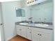 Bathroom features a double sink vanity with white cabinets, gray countertops, and a large mirror at 5371 Lonesome Dove Dr, Kissimmee, FL 34746
