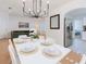 Elegant dining area with modern chandelier, seating for six, and open layout to living area at 5371 Lonesome Dove Dr, Kissimmee, FL 34746
