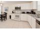 Well-equipped kitchen features white cabinets, stainless steel appliances, and ample counter space at 5371 Lonesome Dove Dr, Kissimmee, FL 34746