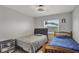 A charming bedroom features two beds and grey wood flooring at 7 Madeira Ave, Orlando, FL 32825