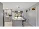 Open-concept kitchen island with seating, pendant lighting, and view of stainless steel appliances and light gray cabinetry at 7 Madeira Ave, Orlando, FL 32825