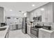 Modern kitchen with gray cabinets, stainless steel appliances, wine rack, and marble flooring at 7 Madeira Ave, Orlando, FL 32825