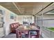 Relaxing screened patio with dining table and sitting area offers the perfect place for entertaining at 7 Madeira Ave, Orlando, FL 32825