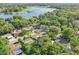This aerial showcases the property, neighboring homes, and lake in the distance, surrounded by lush trees at 7301 Armstrong Rd, Orlando, FL 32810
