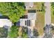 An aerial view shows the house, rooftop solar panels, lush trees, and well-maintained lawn at 7301 Armstrong Rd, Orlando, FL 32810