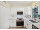 Modern kitchen with white cabinets, stainless steel appliances, and a stylish backsplash at 7301 Armstrong Rd, Orlando, FL 32810