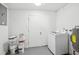 Functional laundry area featuring a washing machine, water heater, and storage space at 7301 Armstrong Rd, Orlando, FL 32810
