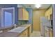 Efficient kitchen layout with white appliances and natural wood cabinets at 830 Airport Rd # 115, Port Orange, FL 32128