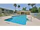 Community pool with lounge chairs and mature palm trees at 830 Airport Rd # 115, Port Orange, FL 32128