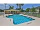 Community pool surrounded by fencing and palm trees at 830 Airport Rd # 115, Port Orange, FL 32128