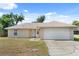 Charming single-story home with a well-manicured lawn, attached two-car garage, and neutral-colored exterior at 831 Lindley Blvd, Deland, FL 32724