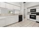 Functional kitchen with white cabinets, black appliances, tiled floor, and plenty of countertop space at 831 Lindley Blvd, Deland, FL 32724