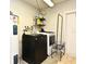 Organized laundry area with washer, dryer, and shelving for cleaning supplies at 8625 Shady Glen Dr, Orlando, FL 32819